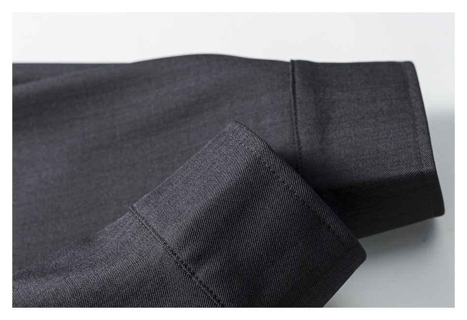 Close-up of a dark charcoal garment sleeve cuff with visible stitching and folded fabric.