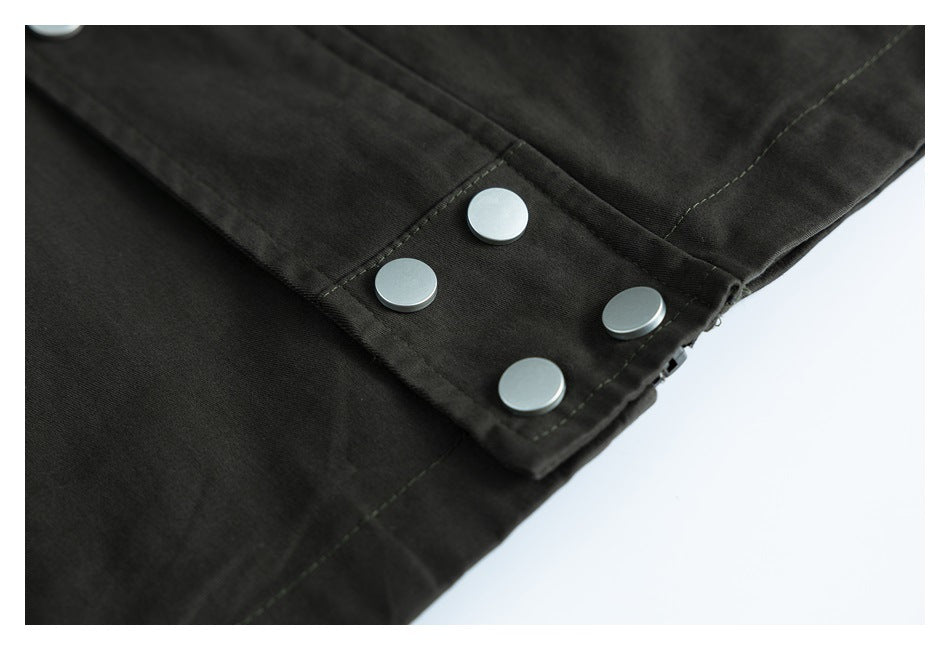Close-up of four silver snap buttons on a black garment panel.