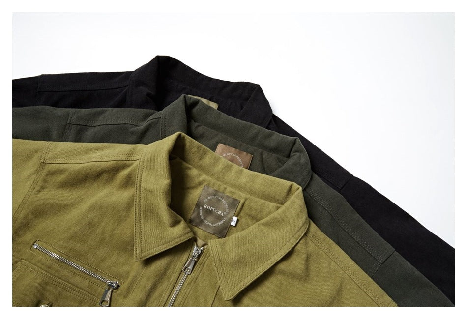 Three workwear jackets in black, dark olive, and mustard, layered to show their collars and front zippers.
