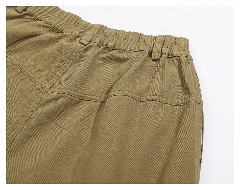 Close-up of the khaki trousers' elastic waistband, belt loops and rear yoke seam.
