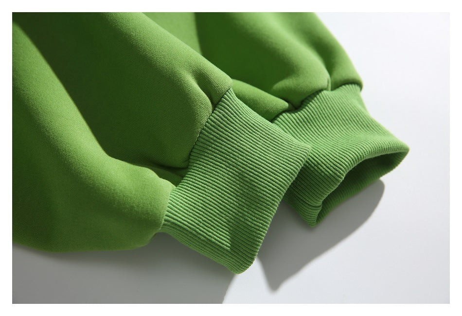 Close-up of the green hoodie’s gathered sleeve and wide ribbed cuff.