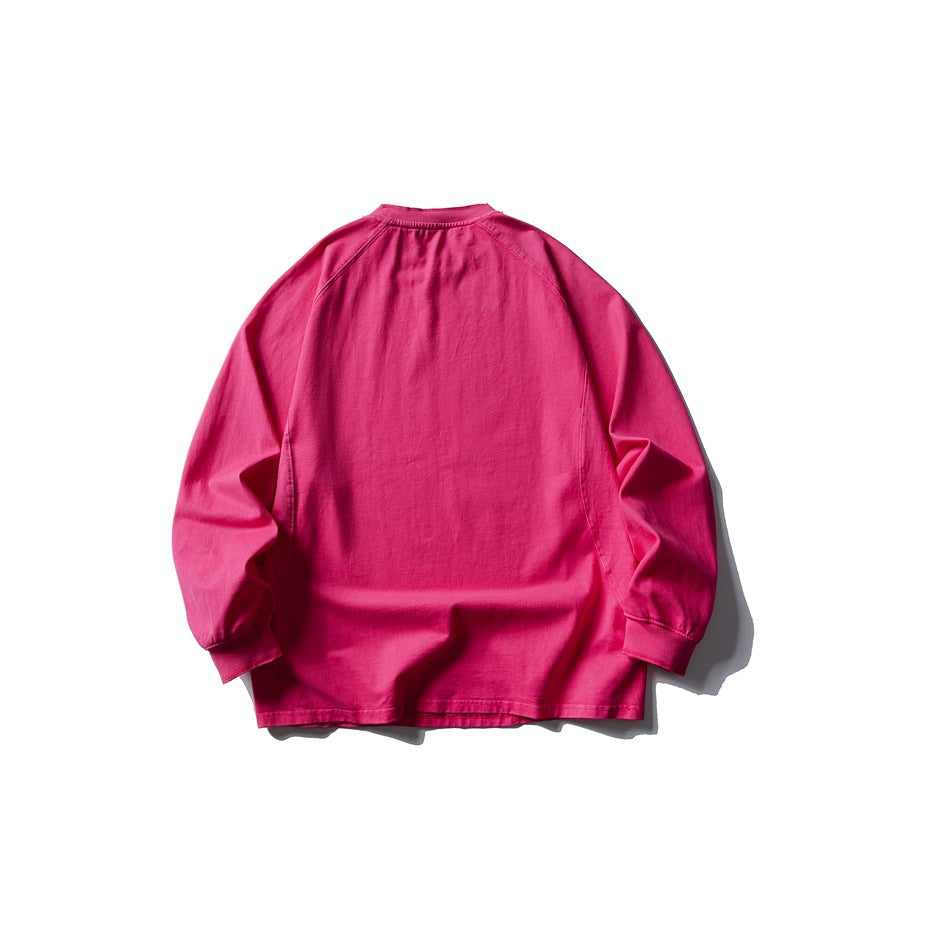 Back view of a bright fuchsia long-sleeve raglan crewneck top with ribbed cuffs and neckline.