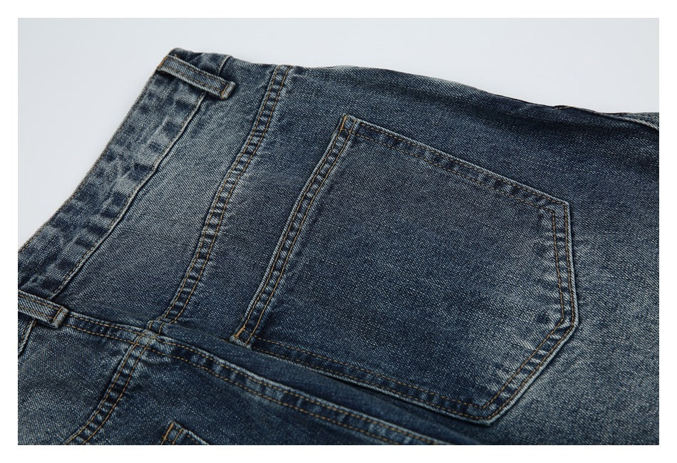 Close-up of a rear pocket and belt loops on blue denim jeans.