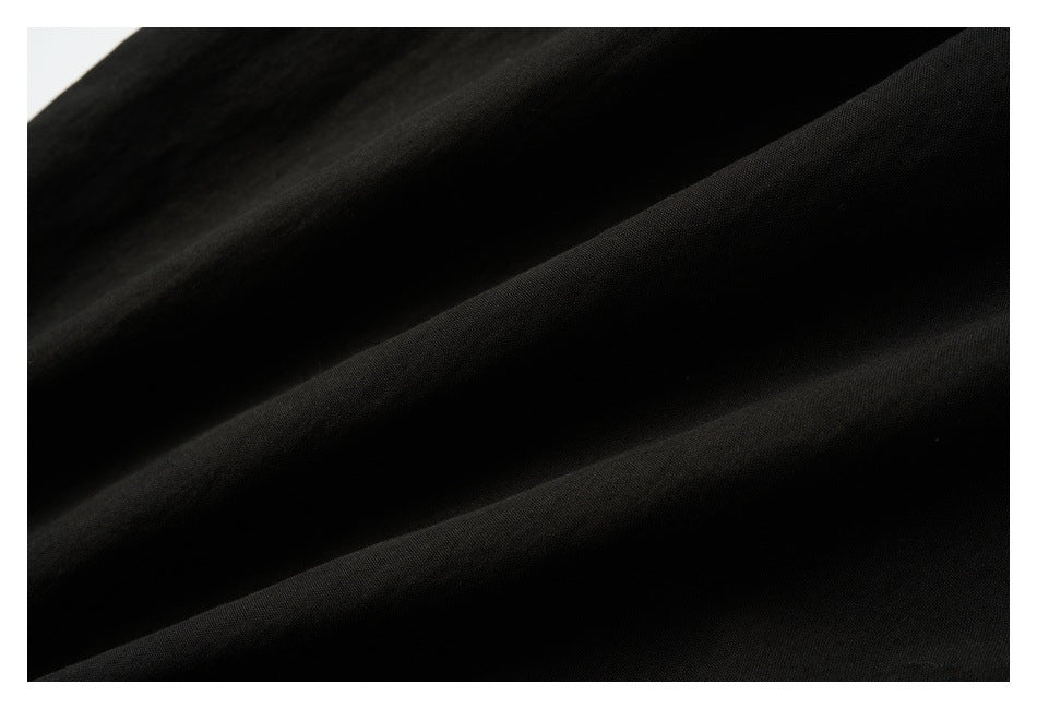 Extreme close-up of black fabric showing its fine surface texture and folds.
