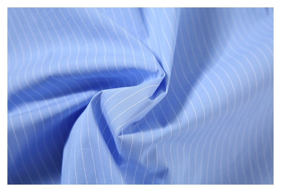 Close-up of light blue fabric with thin white pinstripes folded into soft drapes.