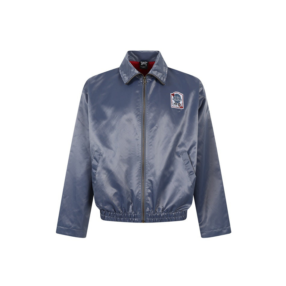Gray-blue satin-finish zip jacket with collar, slanted pockets, elastic hem and chest patch, front view