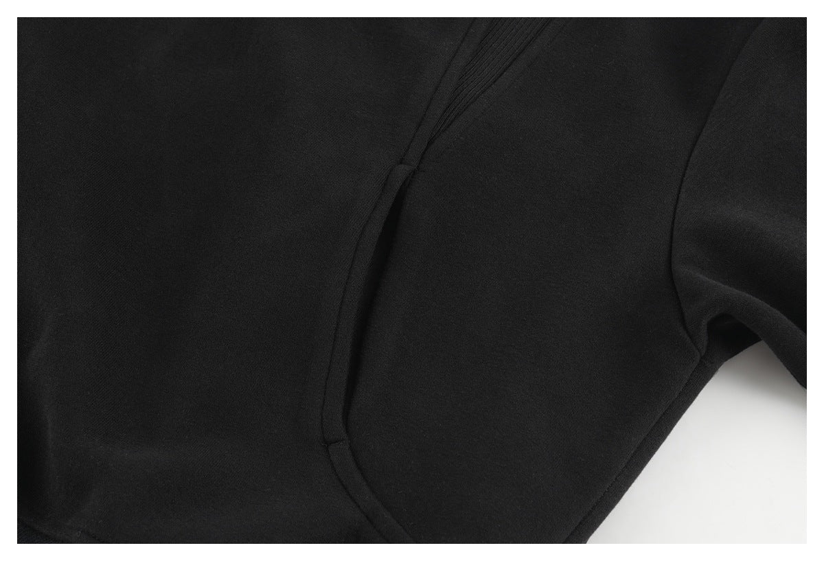 Close-up of a black garment's curved seam and adjacent panel.