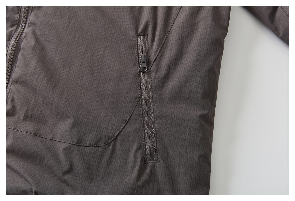Close-up of the jacket’s dark charcoal body and a vertical zip pocket.