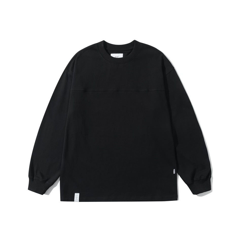Black crew neck long sleeve top flat lay with ribbed collar and cuffs and a yoke seam across the chest