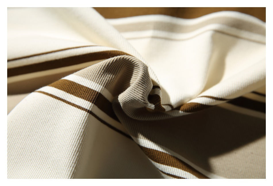 Close-up of folded cream fabric with brown and white stripes and a visible ribbed texture.