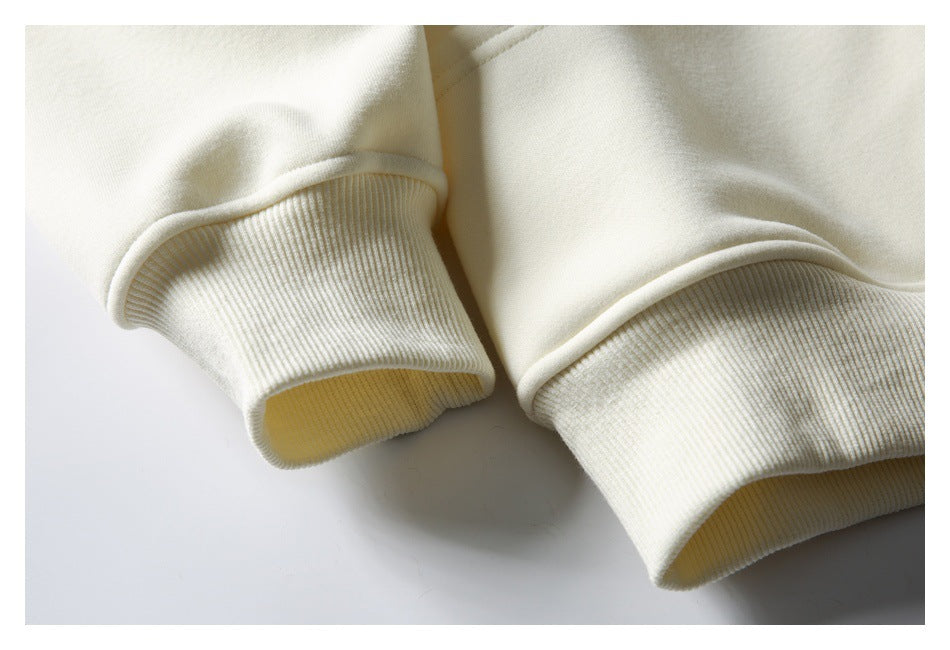 Close-up of two cream sweatshirt sleeves with wide ribbed cuffs.