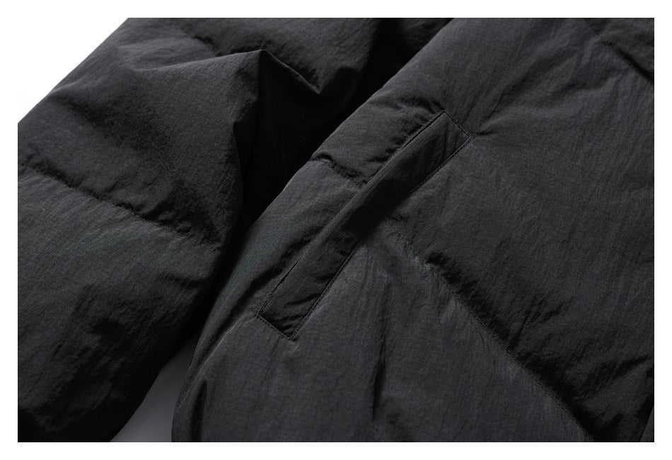 Close-up of black jacket fabric and a narrow stitched pocket opening.