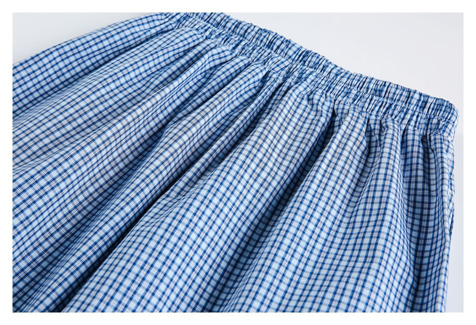 Gathered elastic waistband and draped body of a blue-and-white plaid garment.