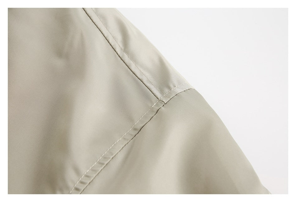 Close-up of the beige jacket's shoulder and sleeve seam stitching.