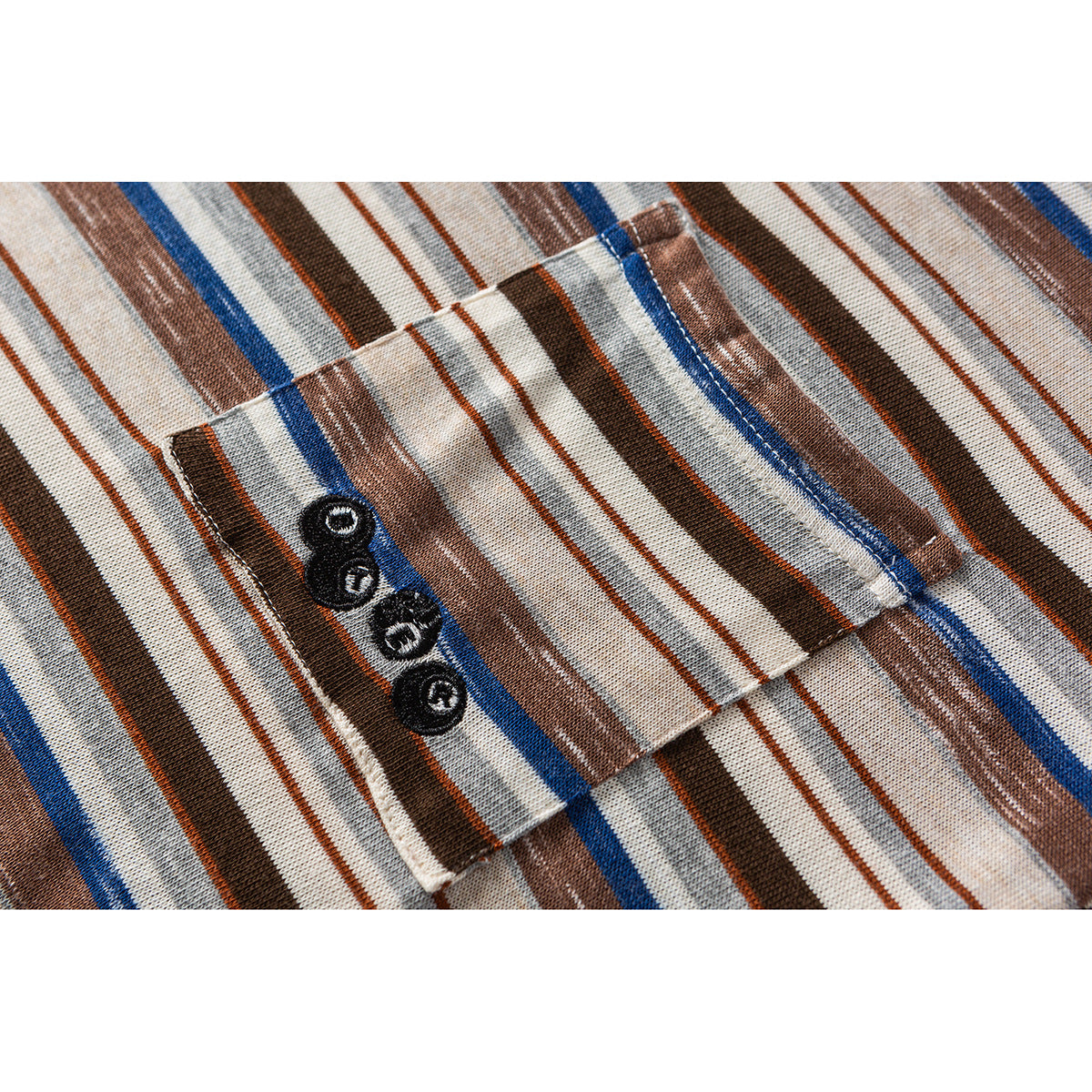 Close-up of a small pocket with four dark buttons on a cream shirt with brown, gray, and blue stripes.