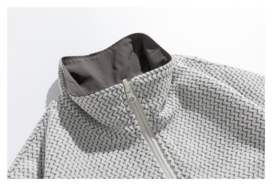 Close-up of a light gray patterned zip jacket with a raised collar and contrasting dark inner fabric.