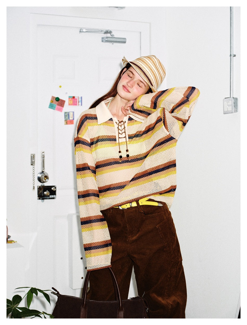 Model posing in a cream open-knit shirt with yellow, brown and navy stripes and a lace-up collar.