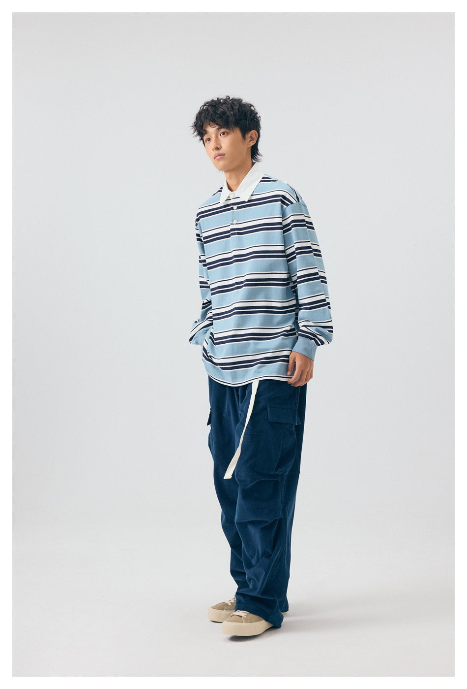 Person wearing a blue, navy and white striped long-sleeve polo top with white collar and navy cargo pants