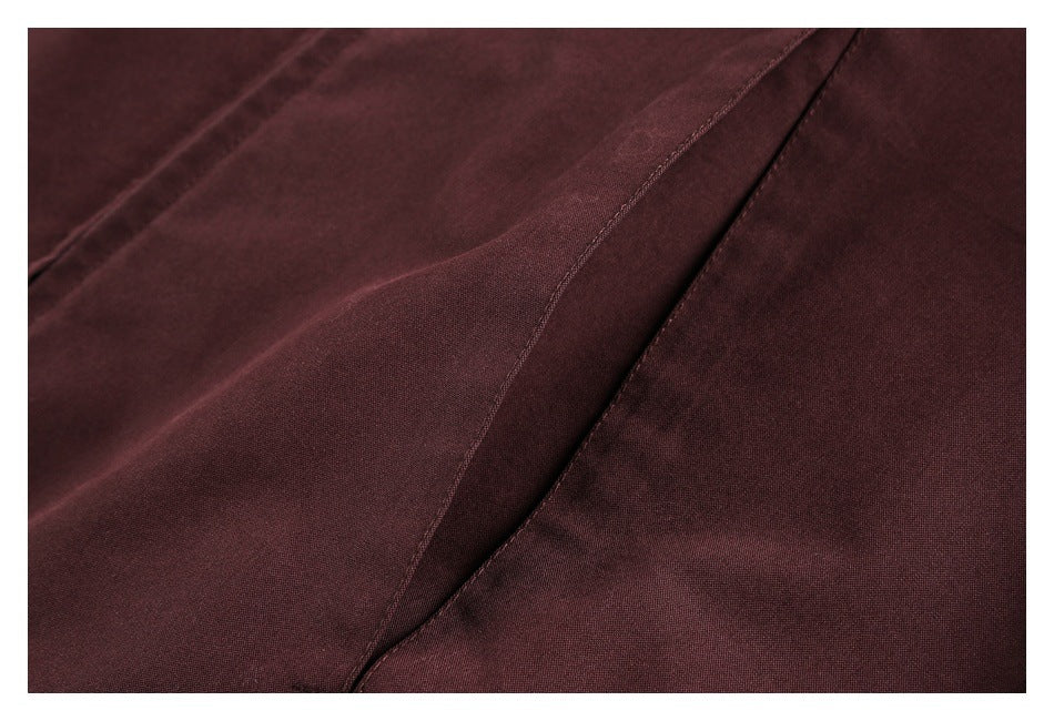 Close-up showing the burgundy jacket's fabric surface and curved stitched seam.