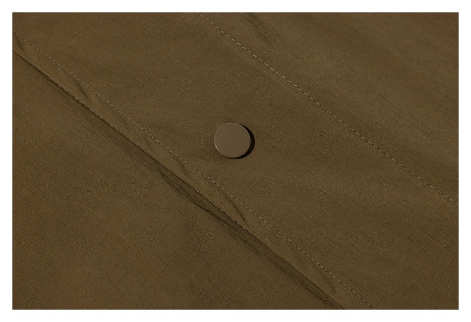 Close-up of a round button and diagonal stitching on olive-brown garment fabric.