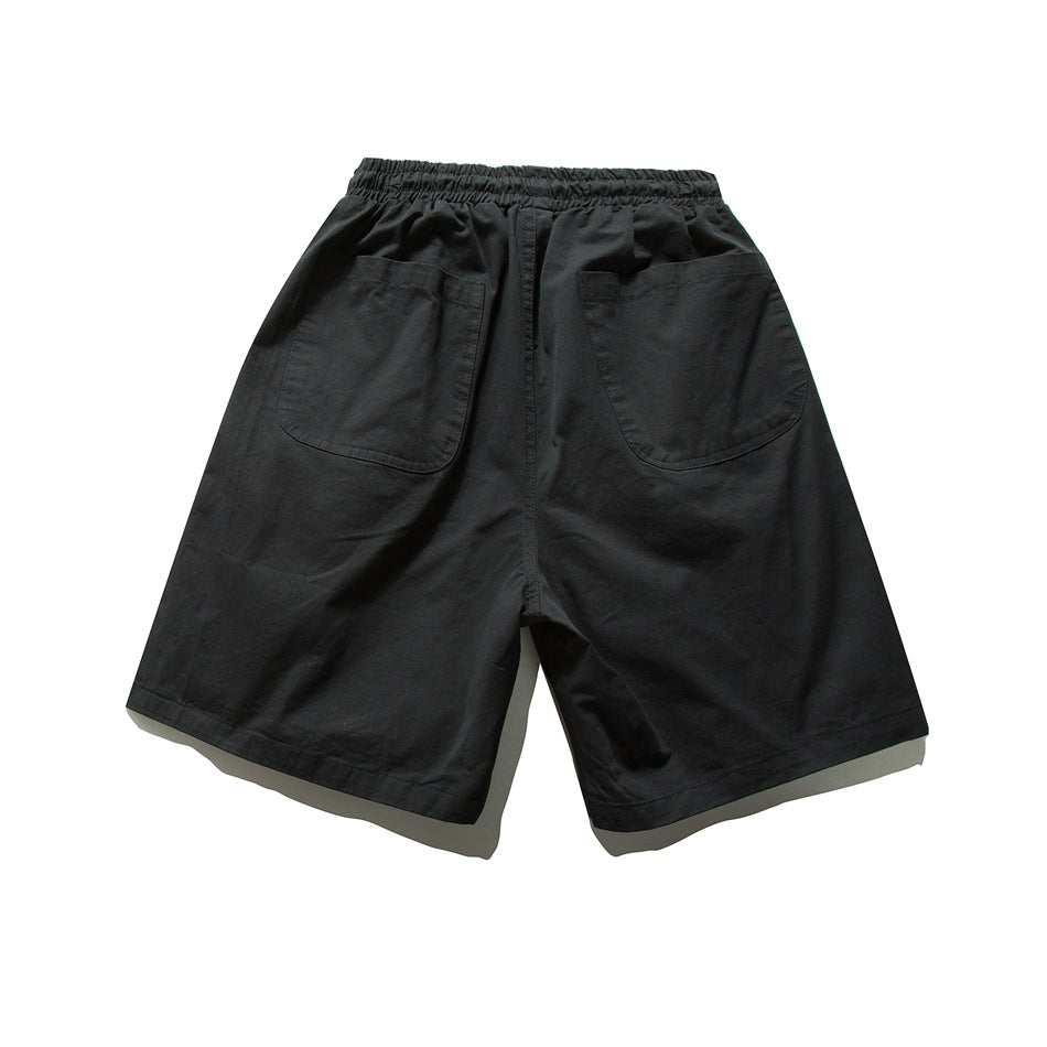 Back view of black wide-leg shorts showing elastic waistband and two large patch pockets