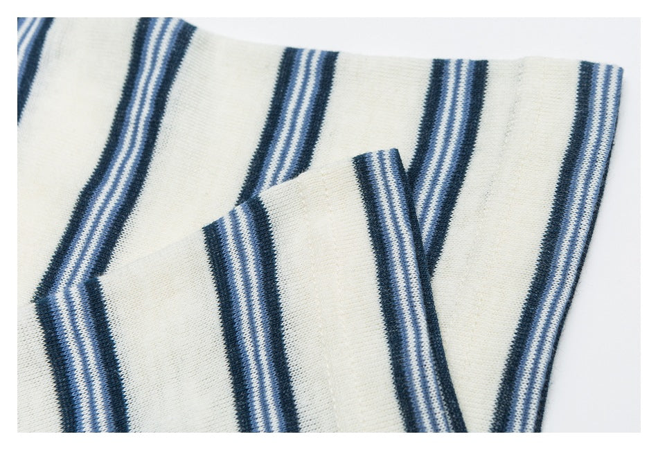 Close-up of a folded edge on ivory knit fabric with vertical navy and pale blue stripes.