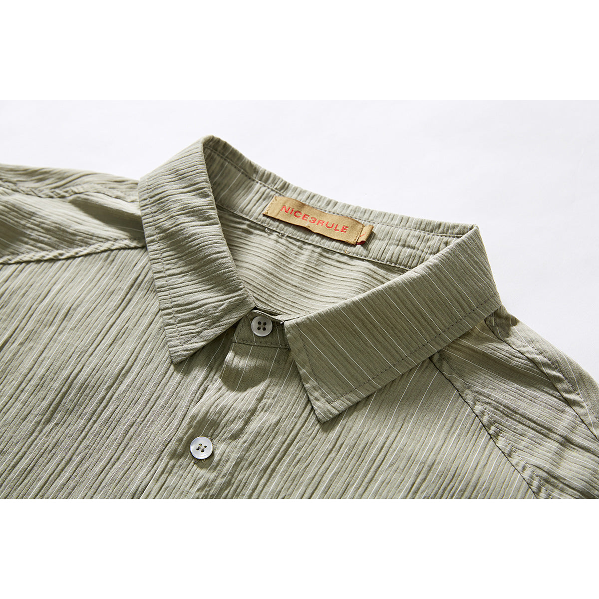Close-up of an olive-gray shirt collar, top buttons, and finely textured vertical stripes.