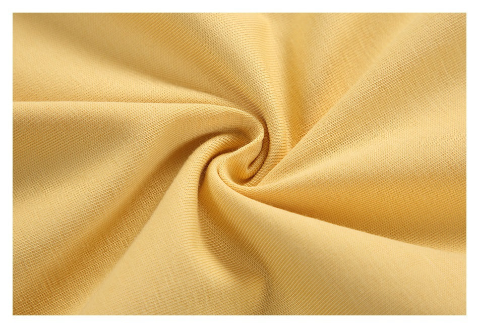 Extreme close-up of pale yellow fabric gathered into folds, showing its knit texture.
