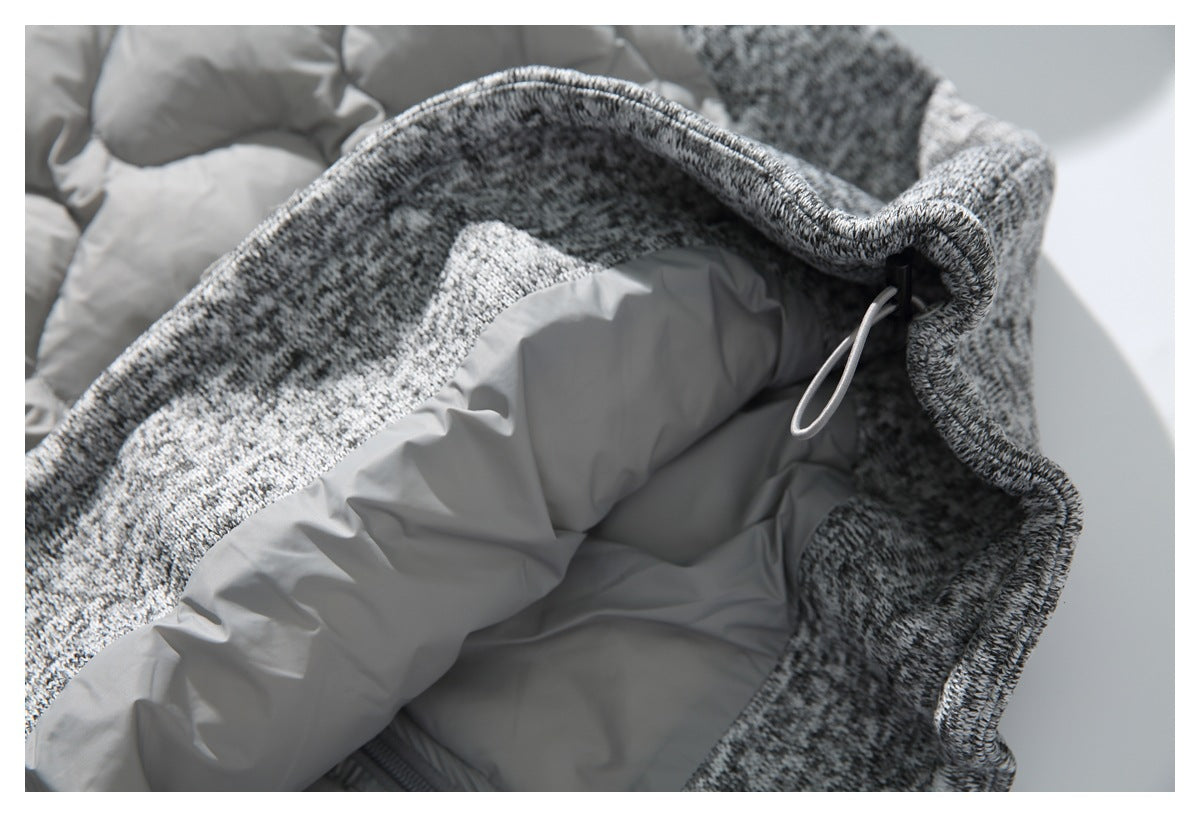 Close-up of a gray drawcord and toggle at the edge of a gray-and-black marled garment with quilted lining.