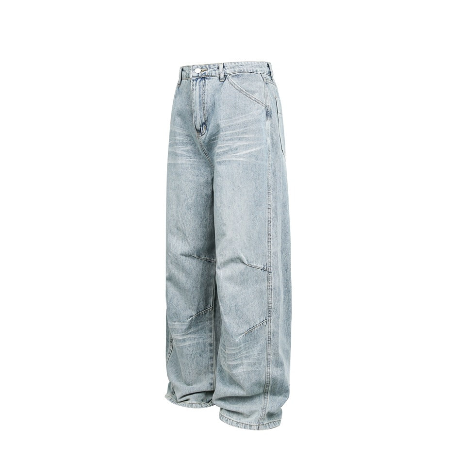 Light blue washed wide-leg jeans shown in three-quarter view on a white background, with whiskering and diagonal knee seams