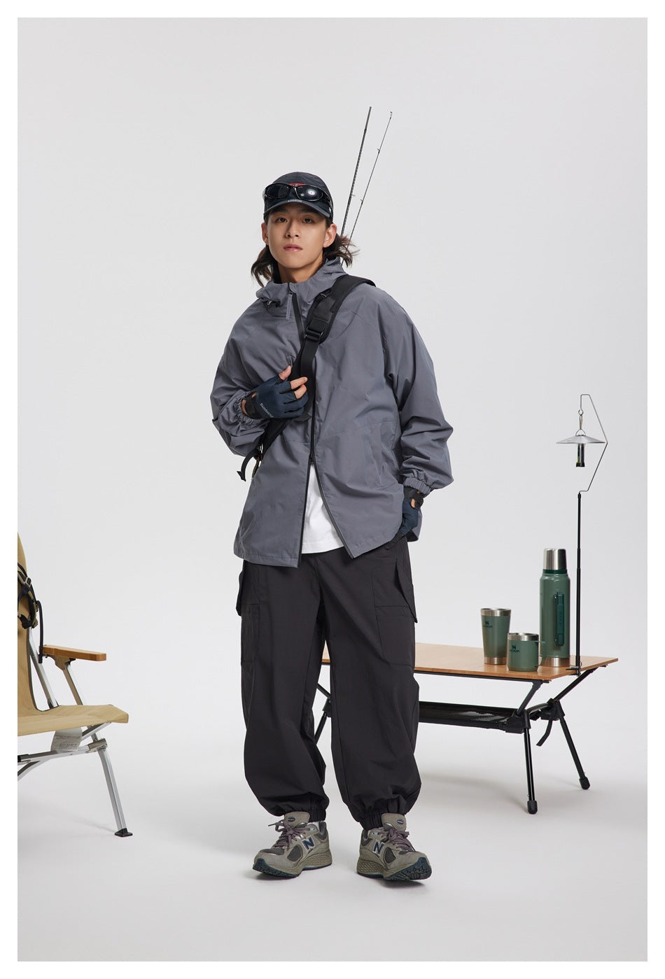 Model wearing a gray hooded jacket with black cargo trousers, shown from the front.