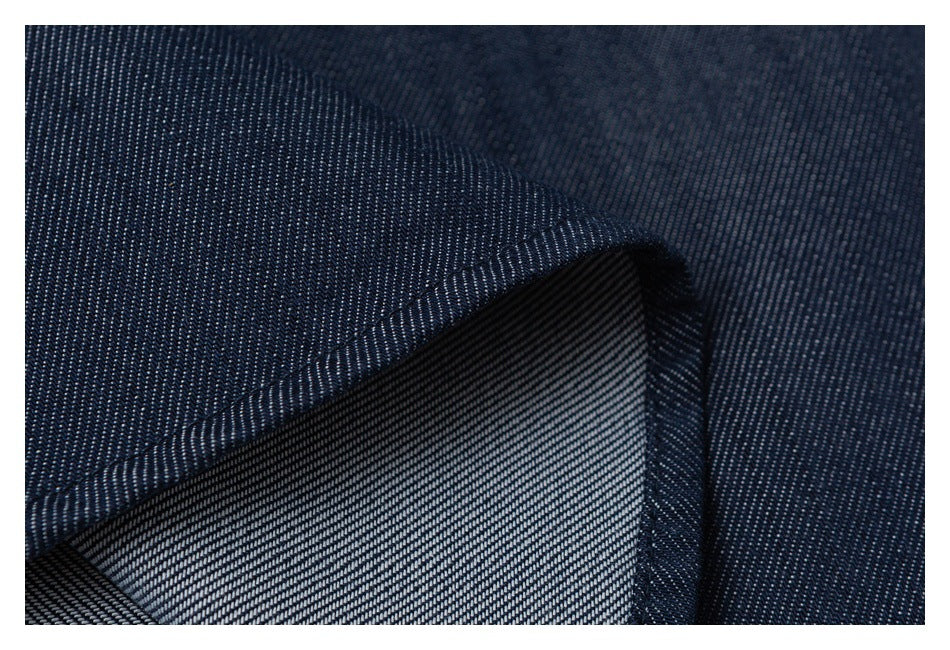 Close-up of a folded seam showing the lighter reverse side of dark navy fabric.
