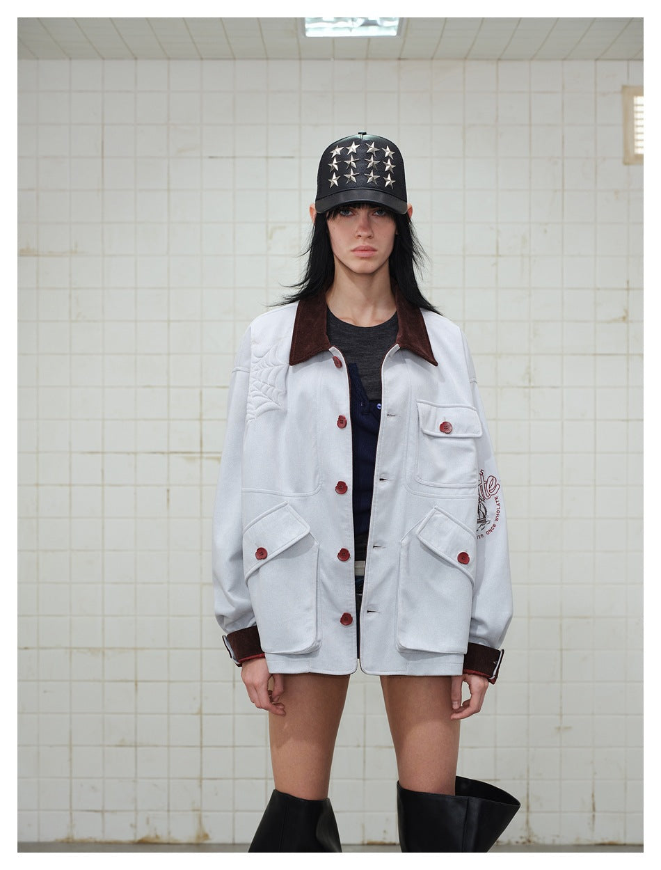 Model wearing a light gray jacket with a dark brown collar, red-brown buttons, flap pockets, and quilted shoulder detail.