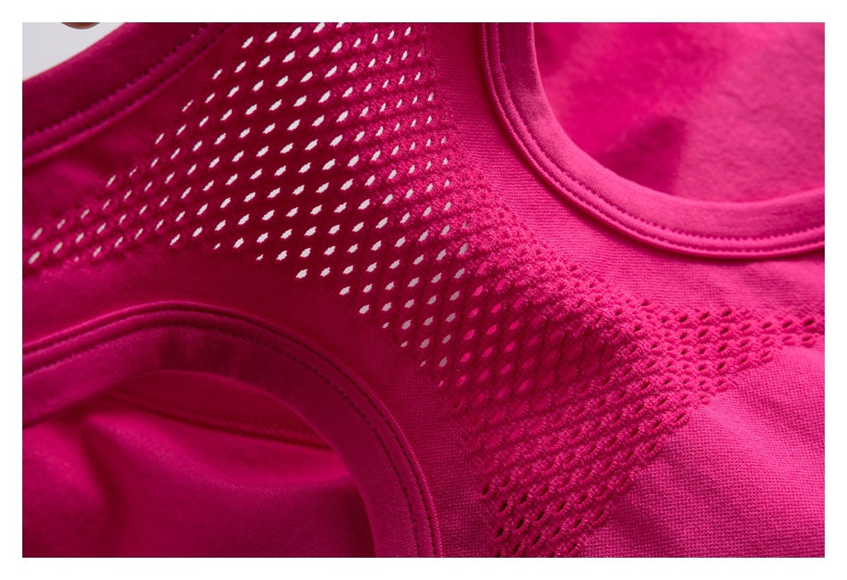 Close-up of a magenta garment showing openwork mesh panels and curved stitched seams.