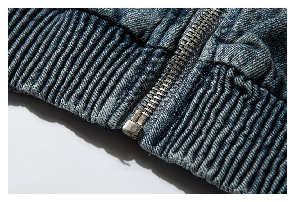 Close-up of a blue-gray denim garment with a metal zipper and thick ribbed edge.