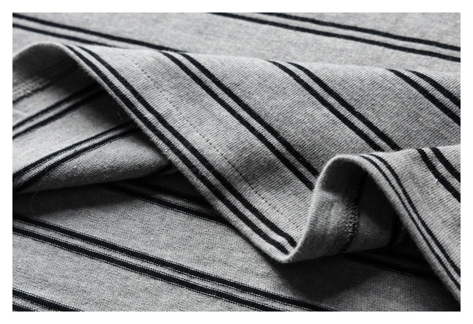 Close-up of the gray and black striped knit fabric, folded to show its stitched edge.