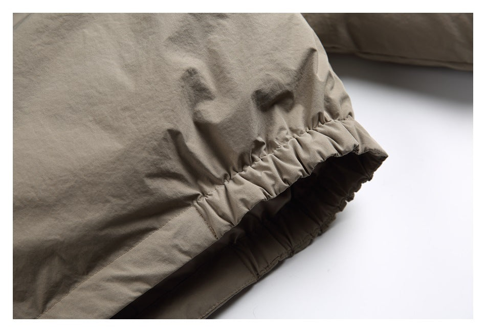 Close-up of taupe fabric with a gathered elastic edge and visible stitching.