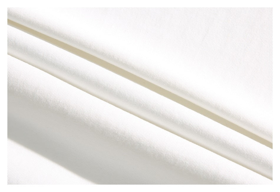 Close-up of smooth white fabric draped in diagonal folds, showing a fine woven texture.