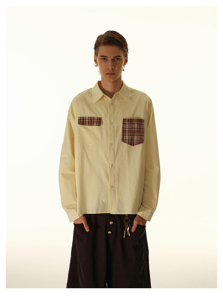 Model wearing an apricot button-up shirt with plaid chest pockets over dark baggy pants, front view