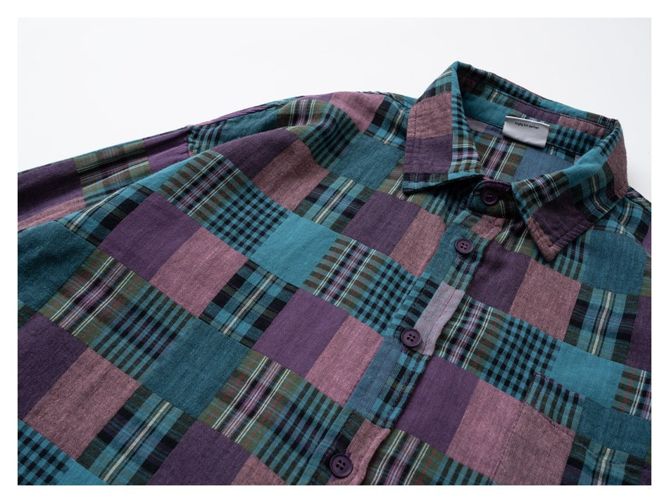 Angled close view of a collared button-front shirt in teal, purple, and dusty-pink patchwork plaid.