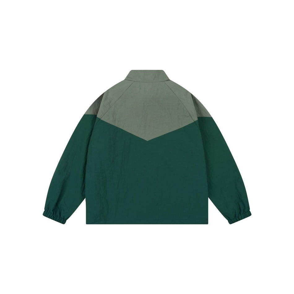 Back view of green two-tone stand-collar jacket flat lay with chevron-shaped upper panel