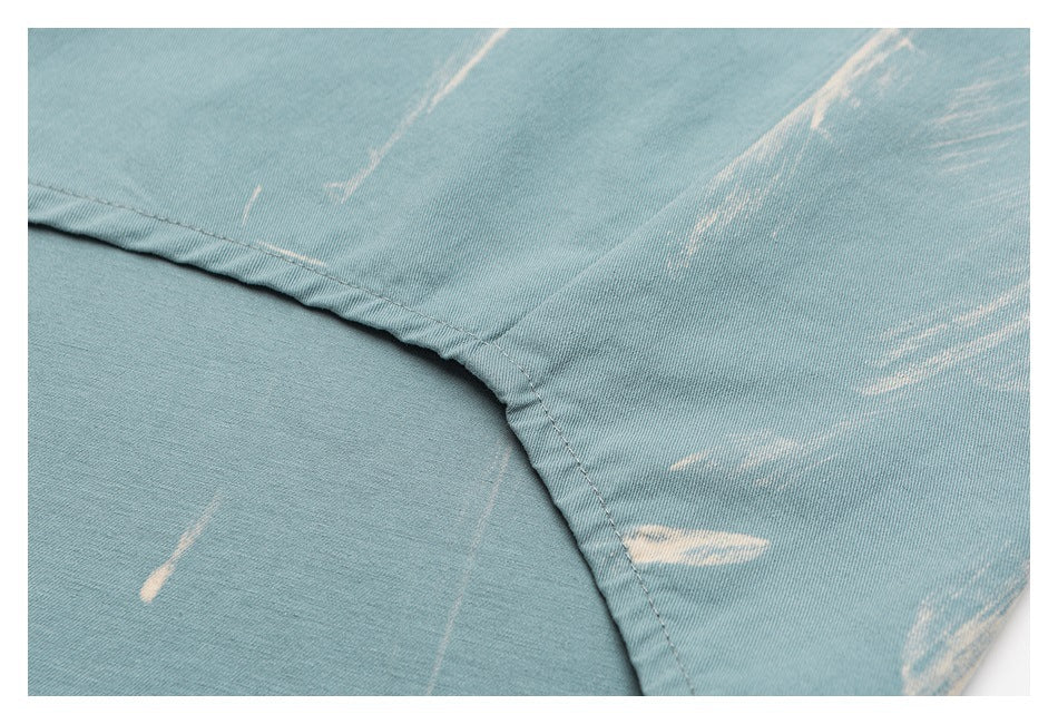 Close-up of a curved seam on pale blue shirt fabric with white streaks.