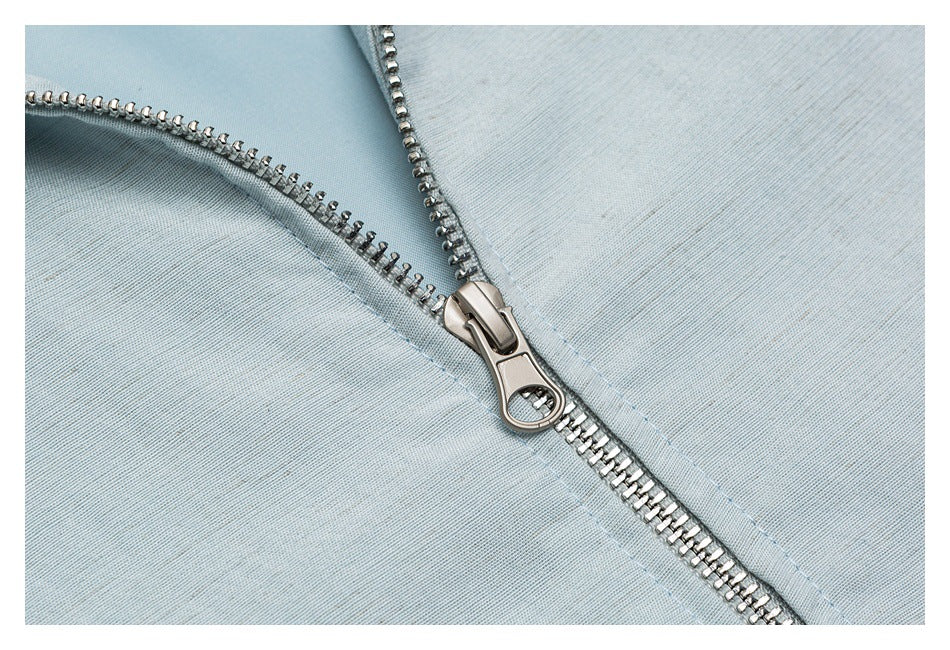 Close-up of a silver metal zipper on pale blue fabric.