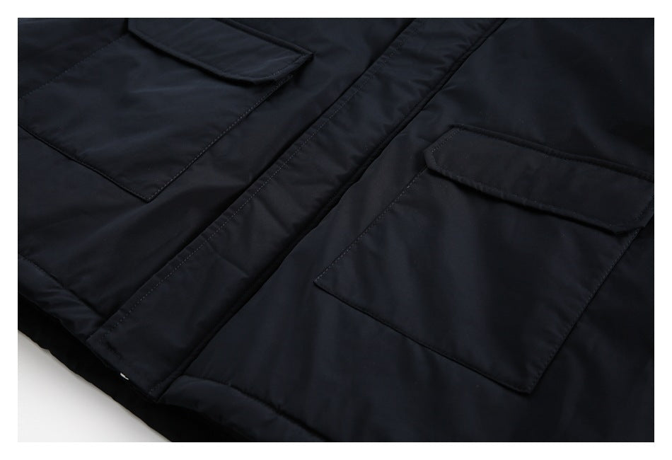 Close-up of two flap pockets and the front placket on a black coat.