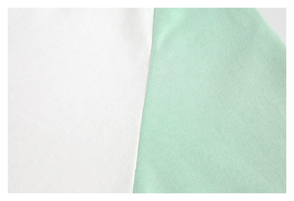 Close-up of white and pale mint-green fabric panels meeting along a diagonal edge.