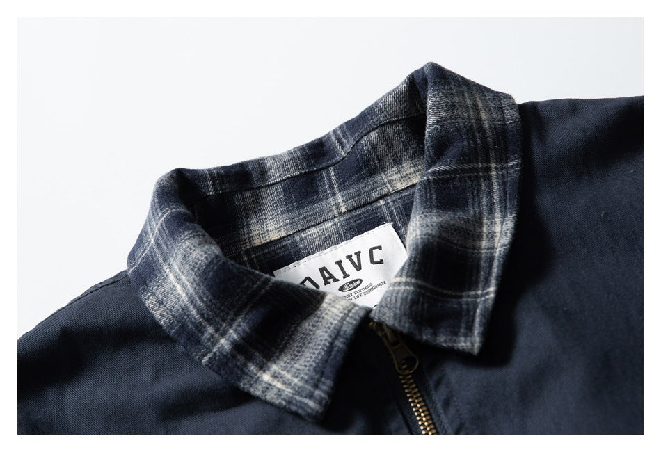Close-up of the jacket's gray plaid collar, inner label, and brass-colored zipper.