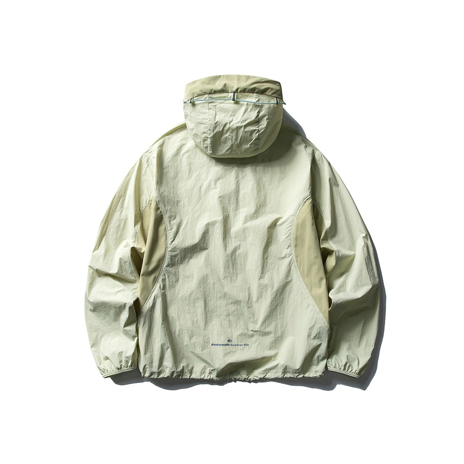 Rear view of a pale sage hooded jacket with an adjustable hood cord and gathered cuffs and hem.