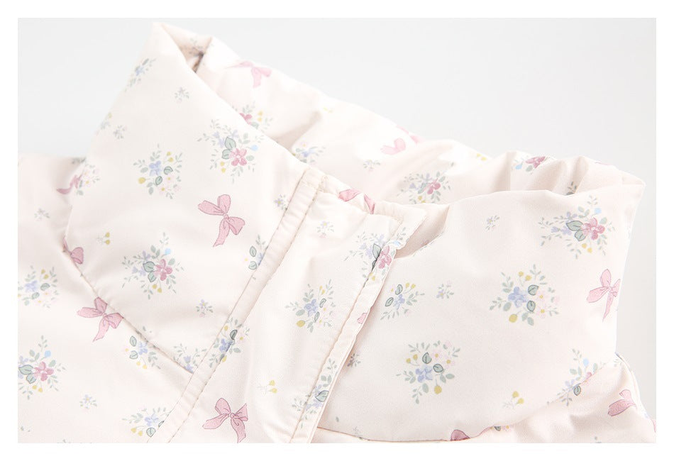 Close-up of a pale pink garment's printed lapel and piped edge, with an ivory printed piece behind it.