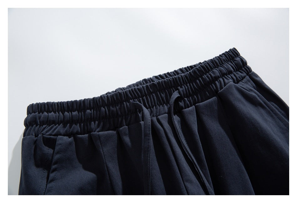 Dark navy pants shown close up, highlighting the gathered elastic waistband and drawstring.