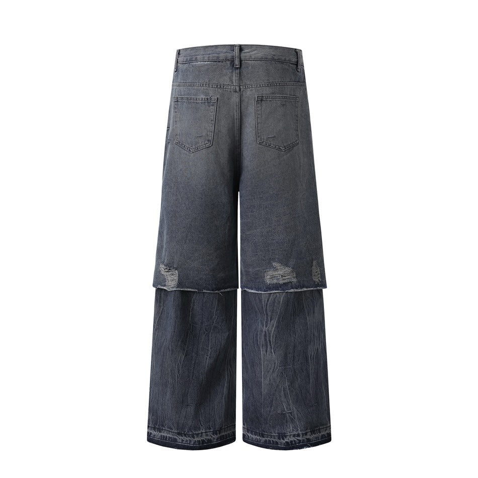 Back view of gray-blue wide-leg jeans with two back pockets, distressed hems, and layered lower legs.